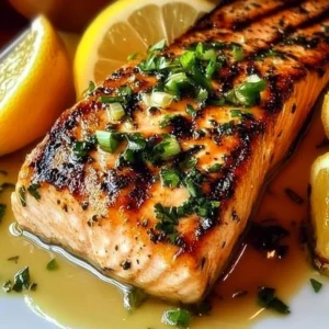 Delicious grilled salmon fillet on a plate with fresh herbs and lemon slices