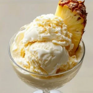 Delicious bowl of homemade pineapple ice cream topped with fresh pineapple slices.