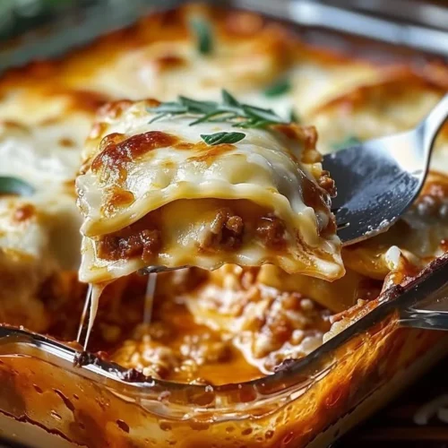 Baked Ravioli Casserole topped with cheese and herbs in a baking dish
