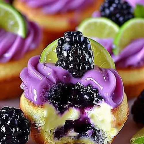 Blackberry lime cheesecake cupcakes topped with fresh blackberries.