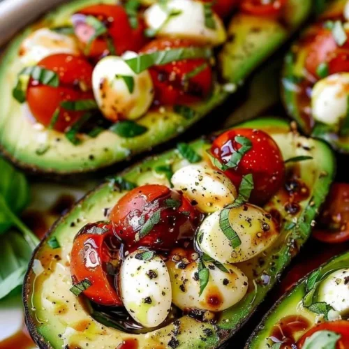 Caprese stuffed avocado with tomatoes, mozzarella, and balsamic glaze.