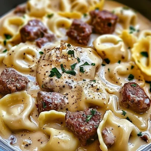 Cheesesteak tortellini in rich provolone sauce garnished with herbs