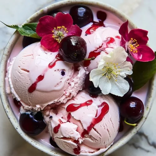 A scoop of cherry blossom ice cream in a bowl, featuring pink, floral design