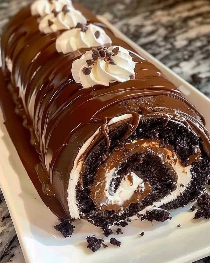 Delicious rolled chocolate cake with creamy filling on a plate