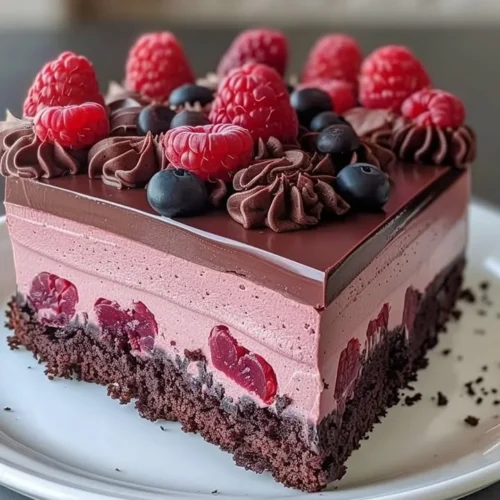 Decadent Chocolate Raspberry Mousse Cake topped with fresh raspberries.