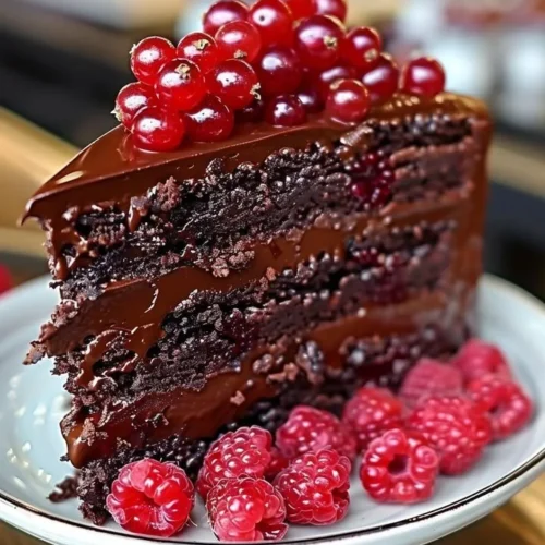 Delicious Chocolate Raspberry Truffle Cake topped with fresh raspberries and chocolate ganache.