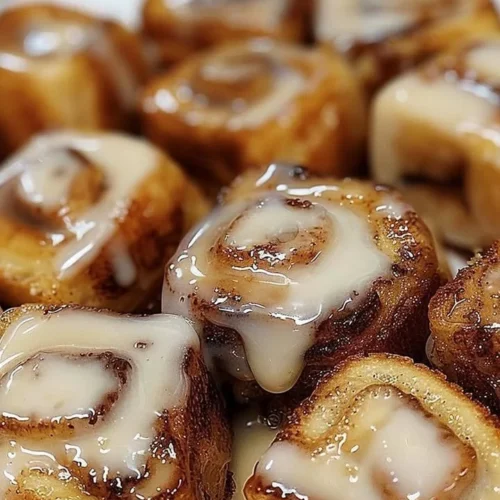 Delicious cinnamon roll French toast bites served on a plate with syrup.