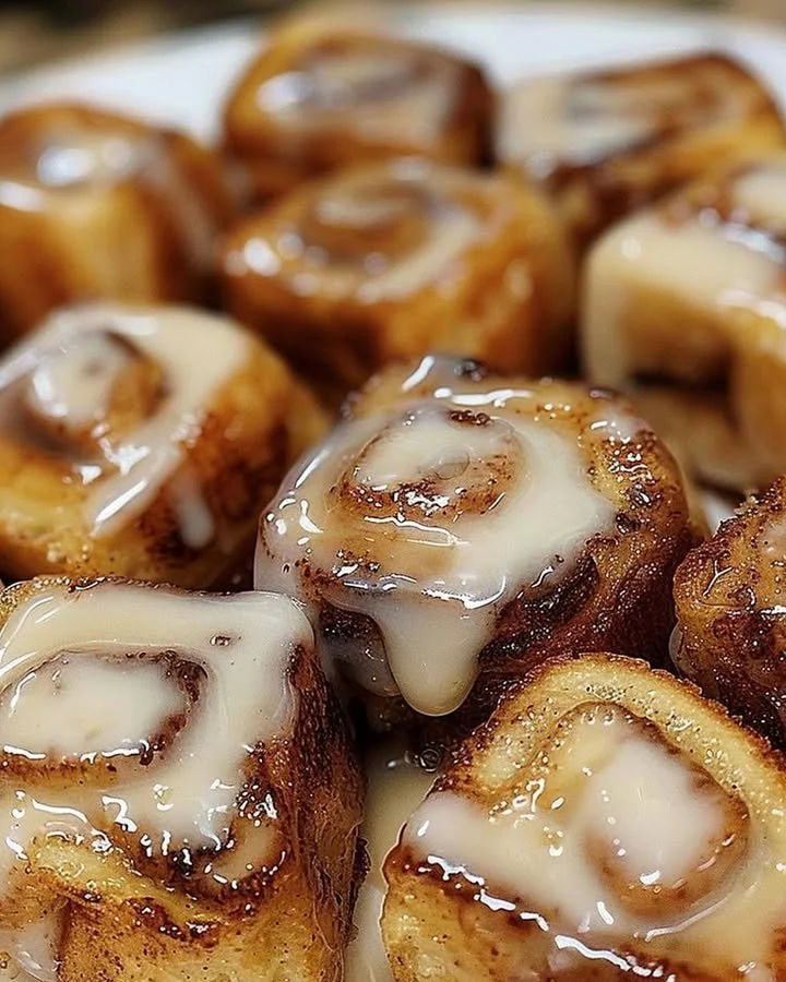Delicious cinnamon roll French toast bites served on a plate with syrup.