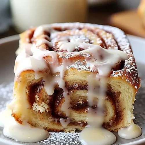 Delicious Cinnamon Roll Poke Cake topped with creamy frosting and cinnamon