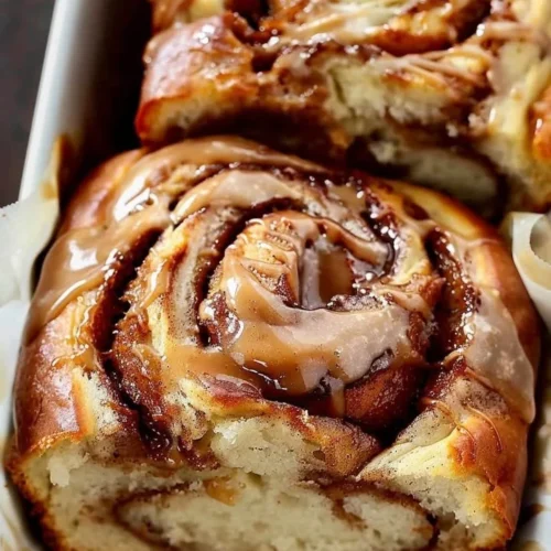 Loaf of freshly baked cinnamon swirl bread on a wooden table