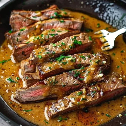 Delicious classic pan-seared steak garnished with herb butter on a plate.