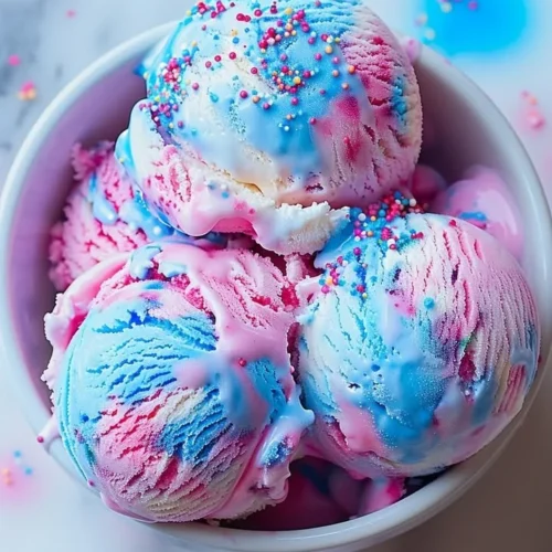 Delicious cotton candy ice cream served in a colorful bowl.