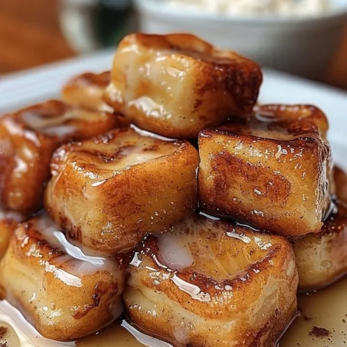 Crispy cinnamon roll French toast bites topped with a sweet maple glaze