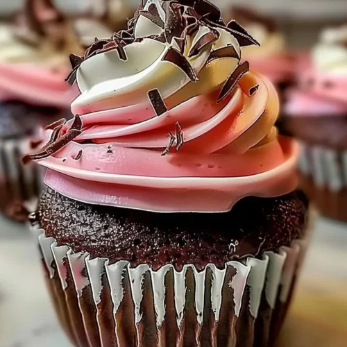 Decadent Neapolitan Cream Cupcakes with chocolate, vanilla, and strawberry frosting.