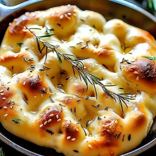 Delicious homemade focaccia bread topped with herbs and olive oil