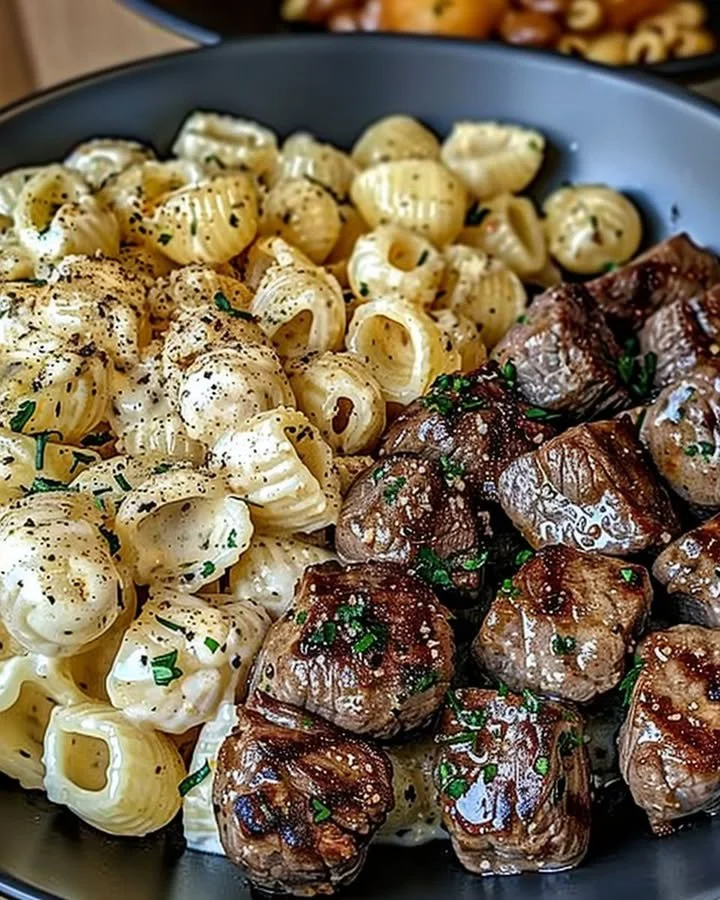 Delicious Garlic Butter Steak Bites served alongside creamy Parmesan pasta shells.