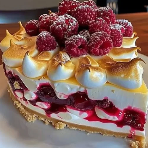 Heavenly Lemon Raspberry Meringue Cheesecake slice on a plate