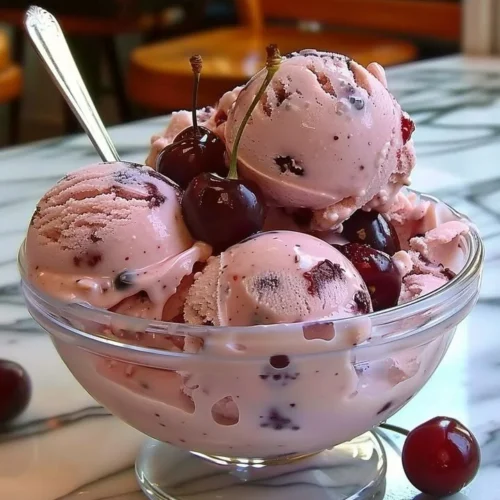 A scoop of creamy homemade cherry ice cream in a bowl.