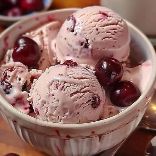 Bowl of homemade cherry vanilla ice cream with fresh cherries on top