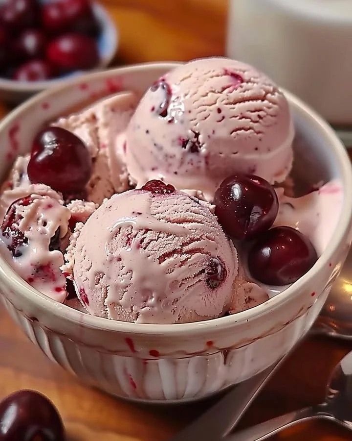 Bowl of homemade cherry vanilla ice cream with fresh cherries on top