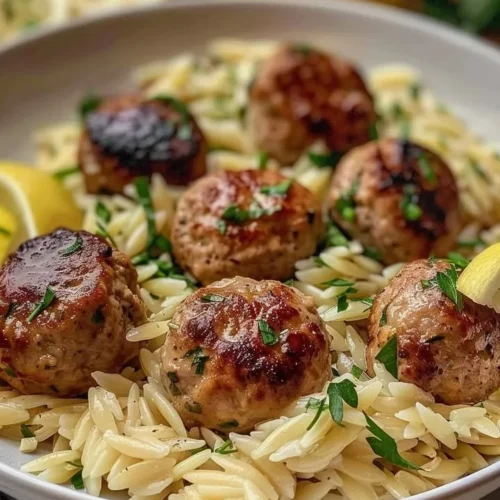 Lemon Chicken Ricotta Meatballs served on a plate with garlic orzo garnish.