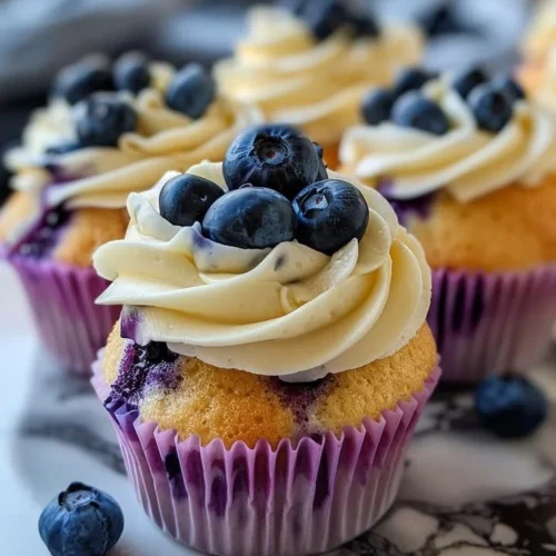Delicious blueberry cupcakes topped with whipped cream and fresh blueberries
