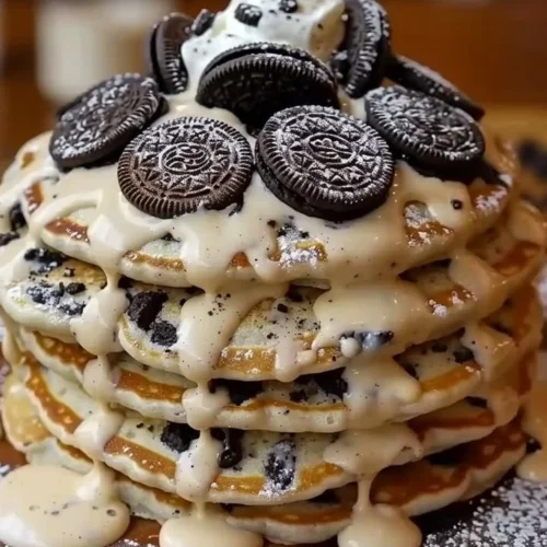 Oreo pancakes topped with cream cheese drizzle served on a plate
