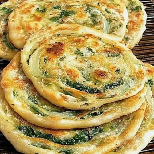 Pan-fried green onion and spinach flatbread served with dipping sauce