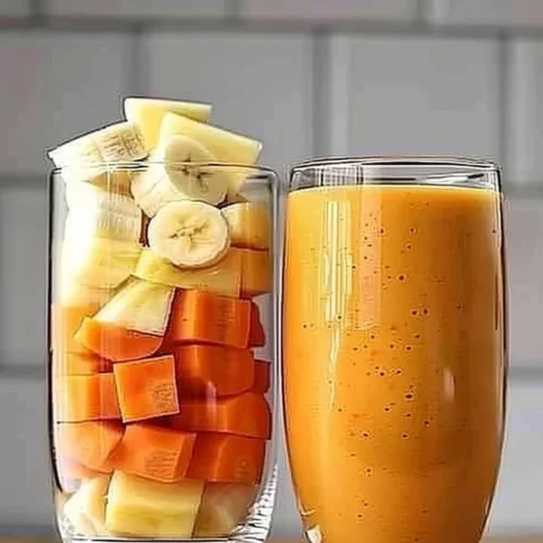 Pineapple Orange Carrot Smoothie in a glass with fresh ingredients