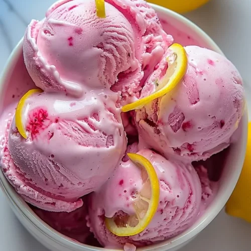 Delicious pink lemonade ice cream in a bowl with lemon slices