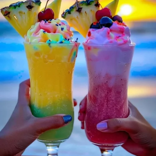 Colorful Rainbow Sherbet Piña Colada in a glass garnished with fruit