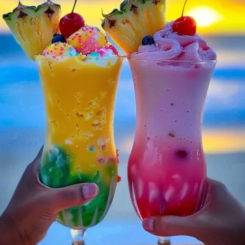 Colorful Rainbow Sherbet Piña Colada served in a glass with tropical decorations.