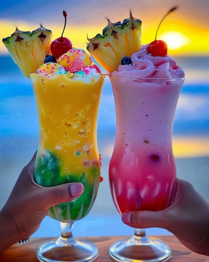 Colorful Rainbow Sherbet Piña Colada served in a glass with tropical decorations.