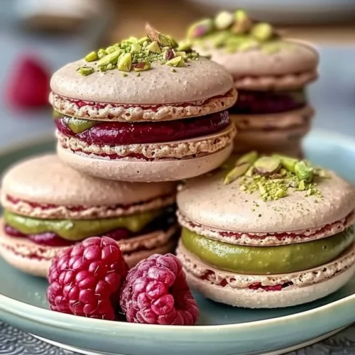 Raspberry Pistachio Macarons on a decorative plate
