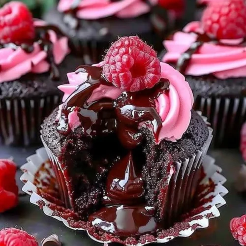 Raspberry chocolate lava cupcakes with gooey centers and fresh raspberries on top.
