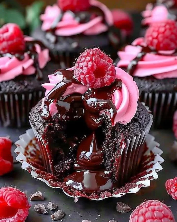 Raspberry chocolate lava cupcakes with gooey centers and fresh raspberries on top.