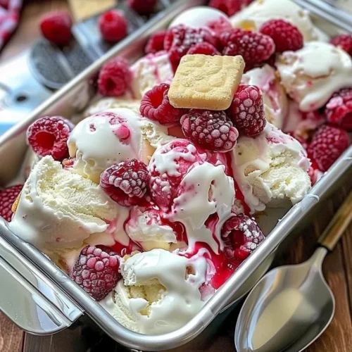 Delicious Raspberry Shortcake Ice Cream topped with fresh raspberries and cake pieces.