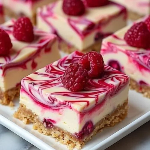 Raspberry swirl cheesecake bars with a creamy texture and vibrant raspberry topping
