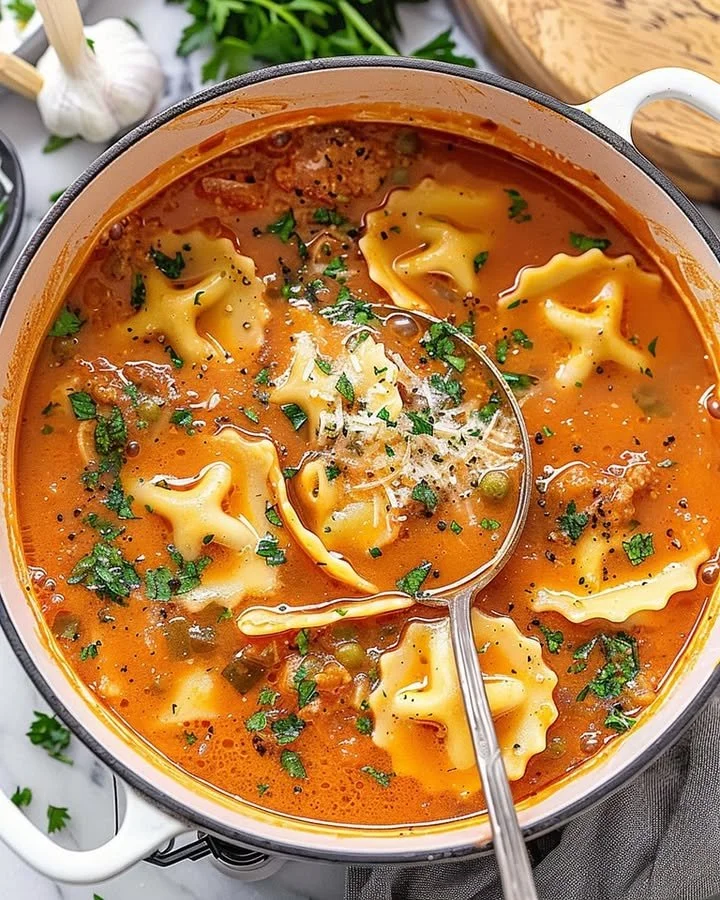 One pot Ravioli Soup served in a bowl with fresh herbs on top