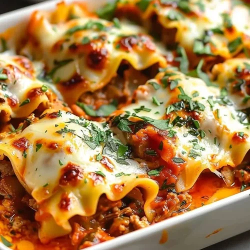 Delicious Short Rib Lasagna Rolls served with fresh herbs and cheese.