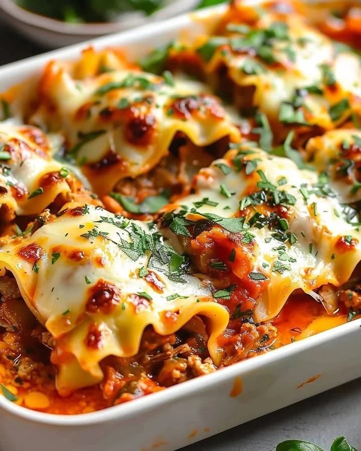 Delicious Short Rib Lasagna Rolls served with fresh herbs and cheese.