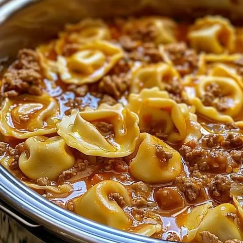 Slow Cooker Cheesy Tortellini in a bowl topped with fresh basil