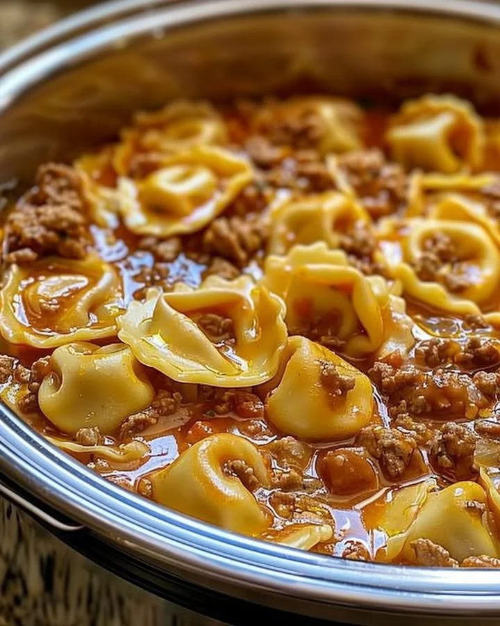 Slow Cooker Cheesy Tortellini in a bowl topped with fresh basil