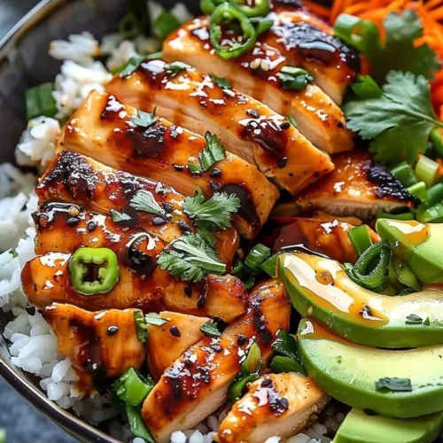 A bowl of spicy honey ginger chicken served with vegetables and rice