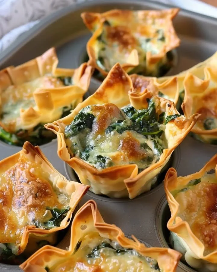 Spinach and artichoke wonton cups served on a plate as an appetizer.