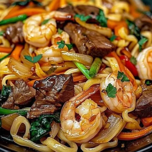 Delicious steak and shrimp stir-fried noodles served in a bowl.
