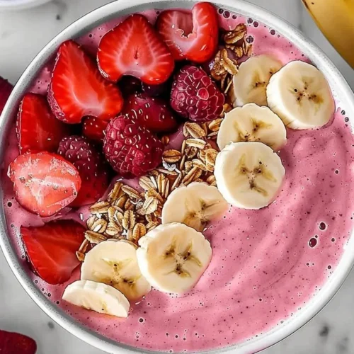 A refreshing strawberry banana smoothie in a glass with fresh fruit