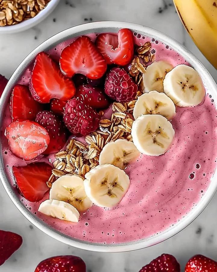 A refreshing strawberry banana smoothie in a glass with fresh fruit