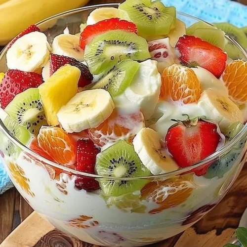 Tropical cheesecake fruit salad with fresh fruits and creamy cheesecake topping