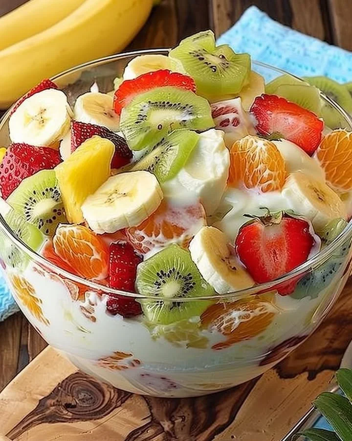 Tropical cheesecake fruit salad with fresh fruits and creamy cheesecake topping